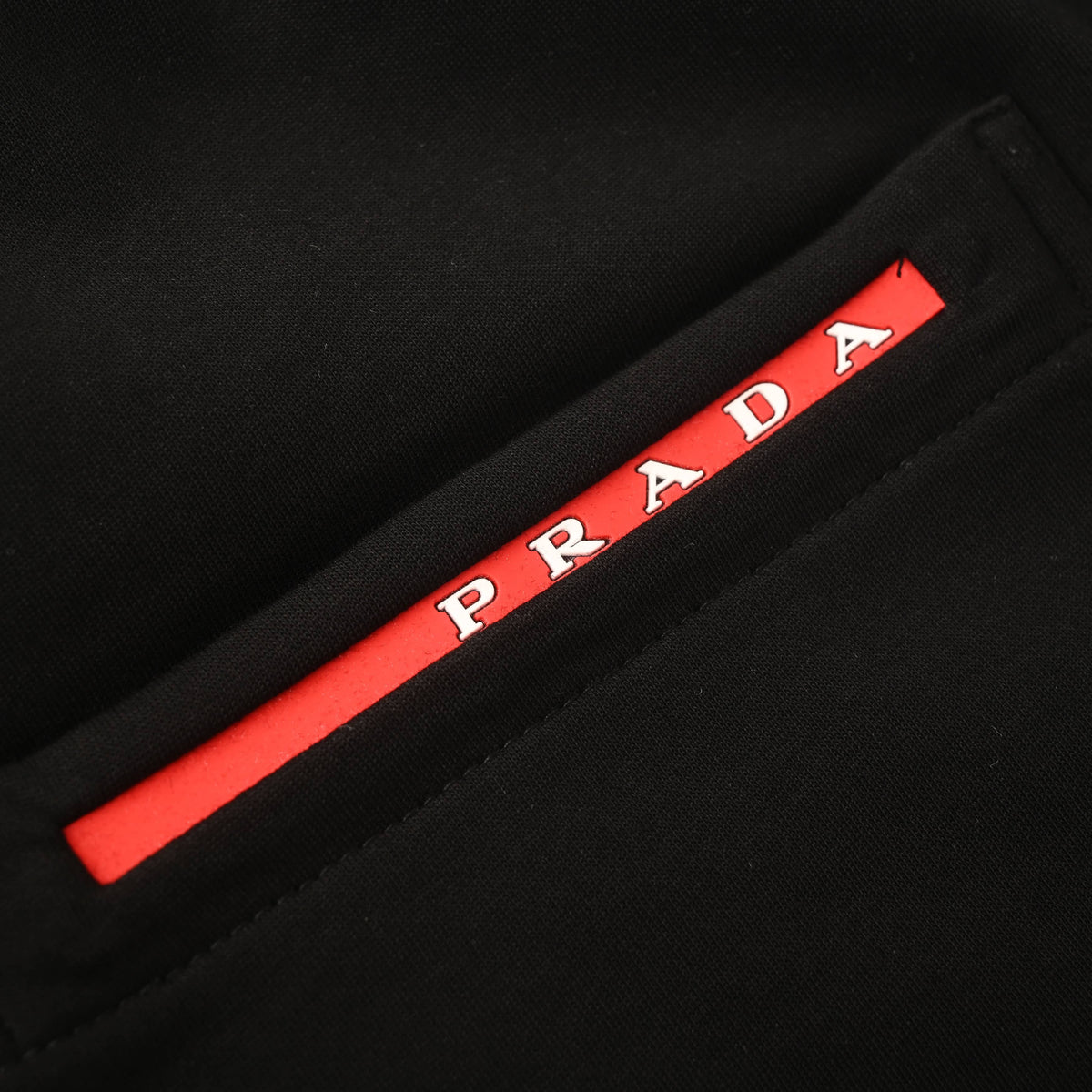 PRADA Black Logo-Panel Tapered Joggers with Red Pocket Detail
